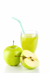 Apple juice in glass and green apples on white.