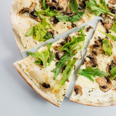 Tasty sliced pizza with mushrooms and arugula