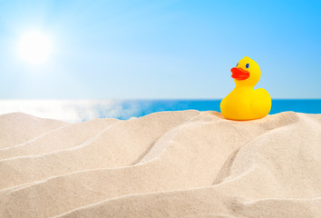 On the Beach - rubber duck on a sand dune in front of beautiful azure sea