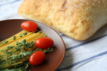 ITALIAN FOOD INGREDIENTS. BREAD, SPAGHETTI, TOMATO AND HERBS.