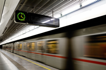 Vienna (Austria) subway underground station with a train running beside the platform