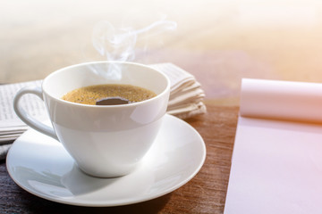 coffee cup clock and news paper on old wooden table nature background
