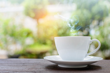 coffee cup clock and news paper on old wooden table nature background