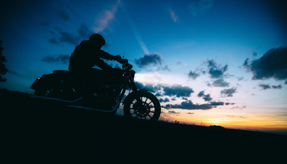 Dark motorbiker silhouette riding high power motorbike