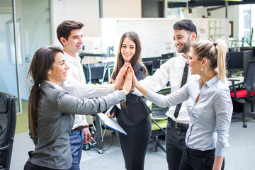 Business people gathering hands in unity celebrating team spirit.