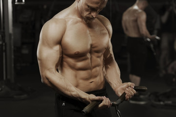 Naklejka na ściany i meble Male bodybuilder working out in machine