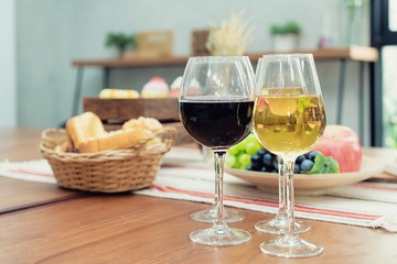 Wine with bread in basket and fruit on the wooden table in restaurant.