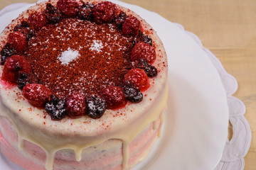 Pie with berries on a plate lies on a wooden table