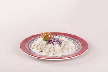 Fish roe salad, whit toasted bread, onion, green leafs, lemon, radish and olives, placed on a white plate, brown background