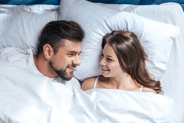 Portrait of young happy loving couple in bed