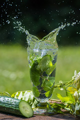 Glass with mineral water with cucumber and mint - home made lemonade