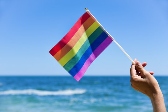 man waving a small rainbow flag