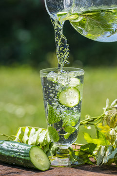 Glass with mineral water with cucumber and mint - home made lemonade