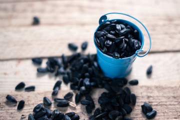 Sunflower seeds on a wooden board on a blurred background.