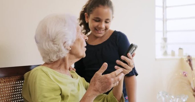 Happy Grandmother And Female Grandchild Using Mobile Phone Smartphone Telephone