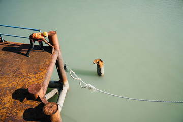 Obraz premium Docker at the wharf takes the mooring end. Old pier.