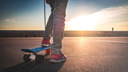 closeup of the feet on the skateboard on the pavement