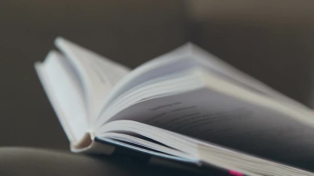 Book pages. The book, reading. A woman's hand holds the pages of the book. A woman's hand turns over the pages of the book. Concept: reading, books, bookmark.