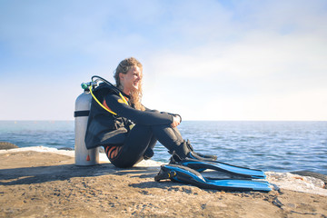 Scuba diver sitting on a pier at the suset © merla