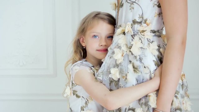 my daughter hugs mother in a long floral dress