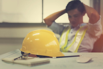 Engineer stress holding his head with hands sitting at the table in the office