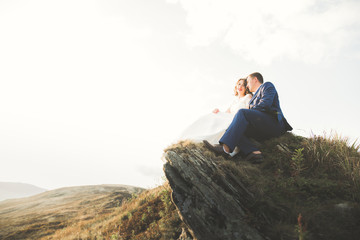 Beautiful gorgeous bride posing to groom and having fun, luxury ceremony at mountains with amazing view, space for text, wedding couple