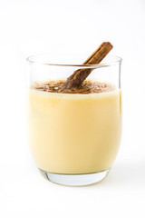 Homemade eggnog with cinnamon isolated on white background. Typical Christmas dessert.

