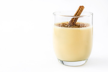 Homemade eggnog with cinnamon isolated on white background. Typical Christmas dessert.


