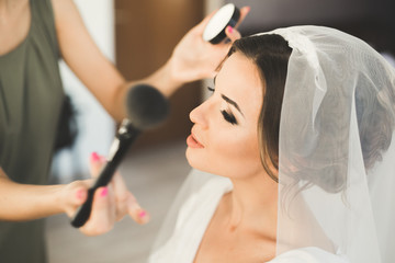 Makeup artist preparing bride to the wedding