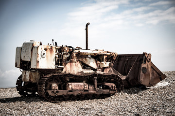 Old disused tractor on shingle beach