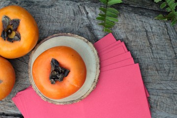 persimmons fruit with red envelopes, Chinese New Year.