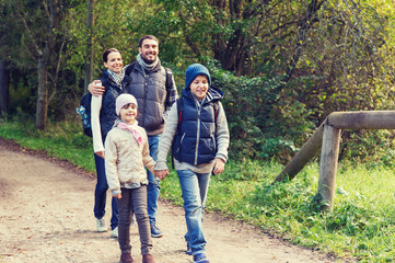 happy family with backpacks hiking in woods