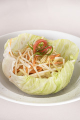 Fresh Coleslaw salad served in a salad &ldquo;bowl&rdquo;, decorated with herbs, placed on white plate, light background, isolated