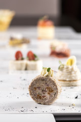 Different types of canapes, placed on individual plates, finger food, dark background