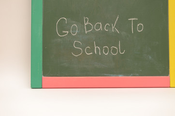 Obraz premium School supplies on a background of a school board with an inscription and on a light background.