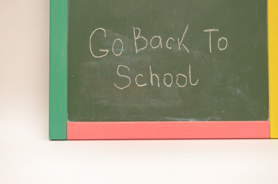 School supplies on a background of a school board with an inscription and on a light background.