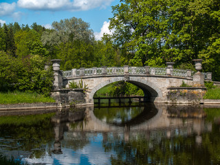 Fototapeta na wymiar Stone bridge on the lake in the park in summer
