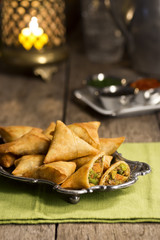 Fried Indian Vegetable Samosas with Three Dipping Sauces in Candlelit Restaurant