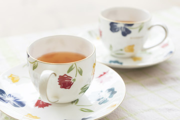 Two beautiful flower pained ceramic cup of tea and hot tea