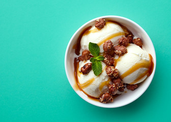Bowl of vanilla ice cream, caramel sauce and nuts