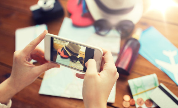 close up of woman with smartphone and travel stuff