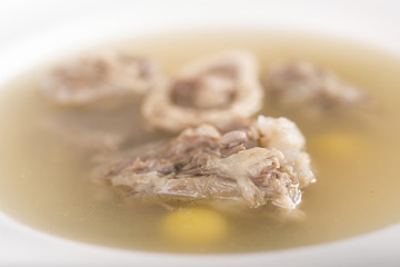 Bone marrow soup, served in a white bowl, light background, isolated