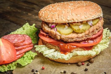 Burger with salami and vegetables