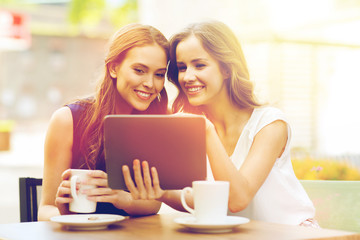 young women with tablet pc and coffee at cafe