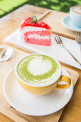 green tea milk latte cup on wood table in coffee shop