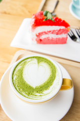 green tea milk latte cup on wood table in coffee shop
