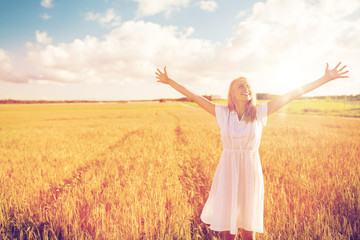 Naklejka na ściany i meble smiling young woman in white dress on cereal field