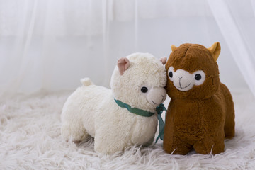 lovely alpaca dolls on the white fur mat