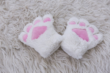 Fototapeta na wymiar white fur cat claw glove on the white fur mat