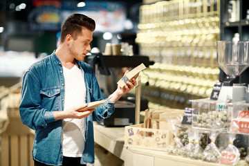 A young man chooses tea in a shop